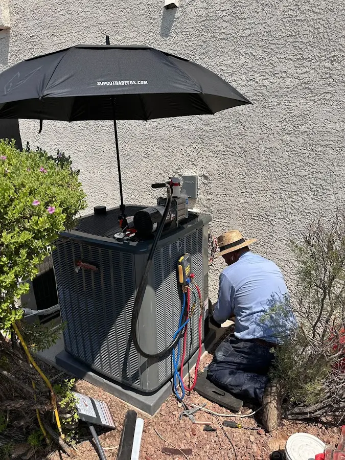 HVAC technician performing outdoor AC maintenance in Las Flores