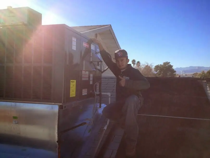 HVAC technician performing AC Tune-Up on a rooftop unit in Las Flores